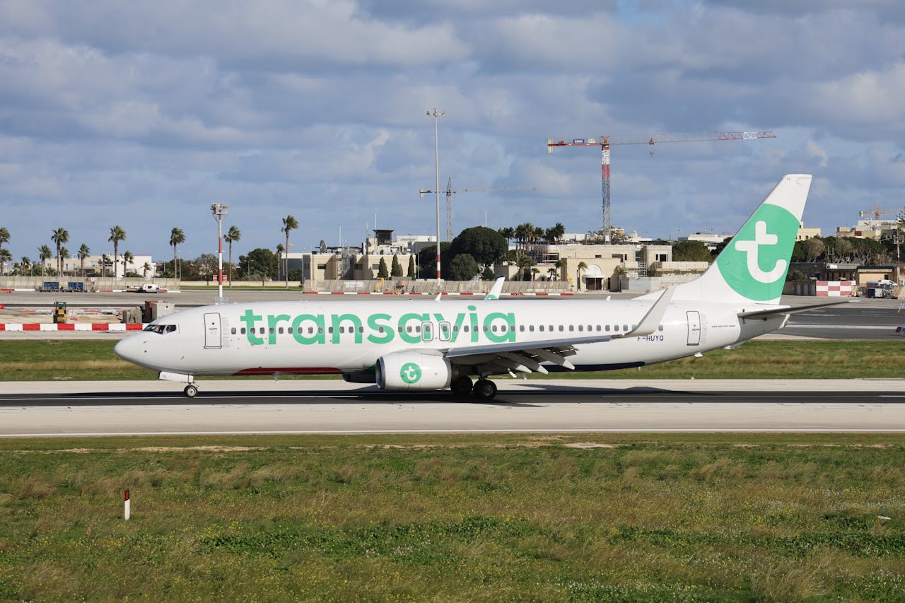 Transavia-vliegtuig maakt zich klaar voor vertrek op een zonnige luchthaven met een heldere hemel